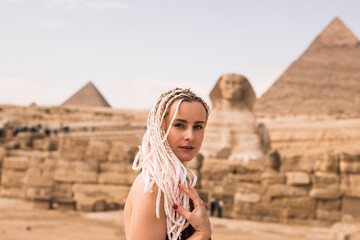 Blonde woman on background of Khafra's Pyramid and the Great Sphinx. Happy women wallking in Egypt