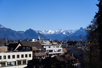 Fototapeta na wymiar Aerial view over City of Luzern seen form local mountain Gütsch on a sunny winter day, focus on background. Photo taken February 9th, 2022, Lucerne, Switzerland.