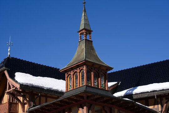 Beautiful Wooden House With Little Tower And Spire And Local Souvenir Shop At Ski Resort Engelberg In The Swiss Alps On A Sunny Winter Day. Photo Taken February 9th, 2022, Engelberg, Switzerland.