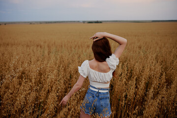woman walking in the field landscape freedom back view