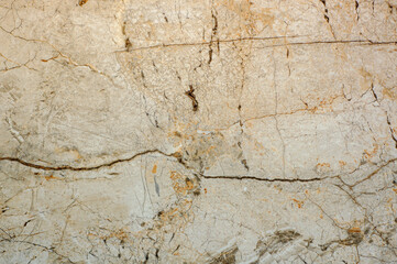 The texture of imitation granite with cracks and spots. Light yellow porcelain stoneware for wall decoration