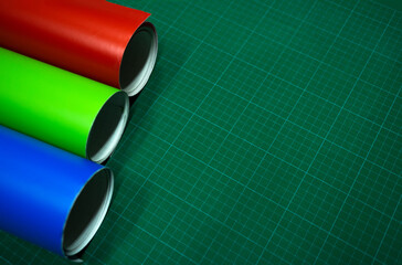 Vinyl self-adhesive film in round rolls on a marking table. Work with film for pasting shop windows...