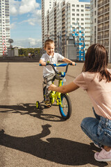 Boy rides a bike to his mother.