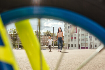 Mom walk with son on the playground.