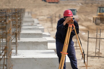 Fototapeta premium Almaty, Kazakhstan - 04.24.2018 : An engineer takes measurements at a construction site.