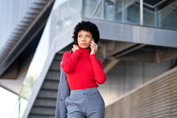 Elegant African American woman using mobile phone in an office building