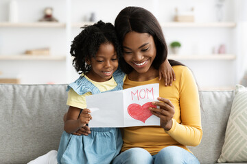 Mother's Day. Little Daughter Giving Greeting Card To Happy Mom At Home