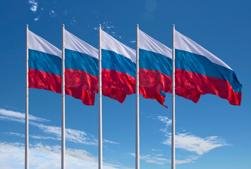 Five flags of Russia. Cloudy blue sky in the background.
