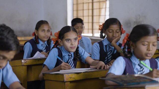 handheld shot of kids busy writing notes from blackboard at classroom - conept of knowledge, education, growth and development.