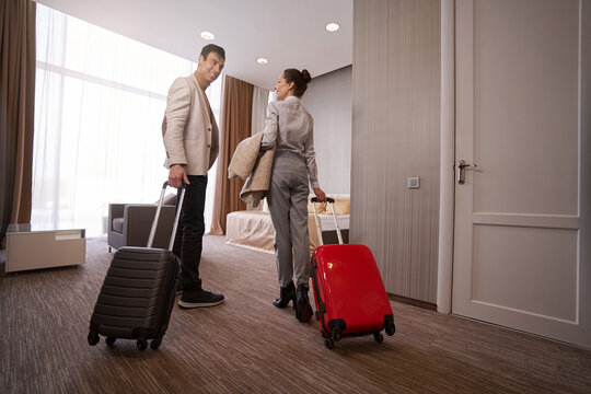 Loving couple with baggage in hotel room