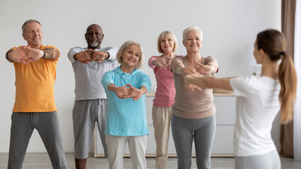 Sporty elderly people having fitness class, training with instructor - Powered by Adobe