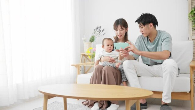 スマートフォンを赤ちゃんに見せる両親