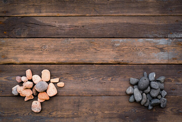 Sea pebbles stones on the wooden table flat lay background with copy space.