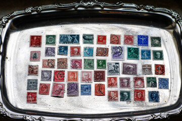 Vintage postage stamps on a silver plate