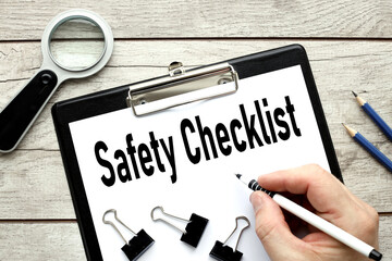 Safety Checklist. folder with a clip on a white sheet of paper on a wooden background. business...