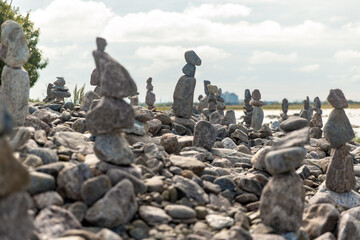 nature, harmony and balance - stone pyramids or towers on beach