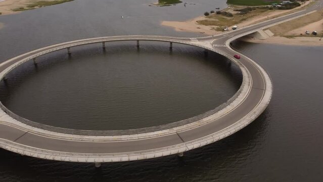 A drone over Laguna Garzon Bridge as a red car drives over.