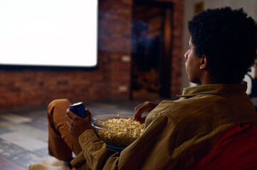 Man enjoy watching film using video projector - obrazy, fototapety, plakaty
