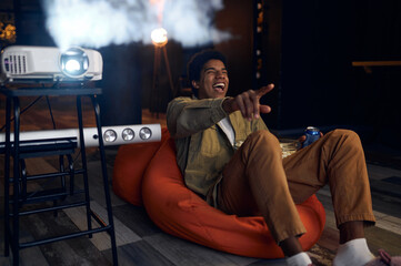 Happy young man laughing during watch film