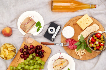 leisure and eating concept - close up of food, drinks and vintage film camera on picnic blanket