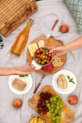 leisure and eating concept - close up of hands holding bowl with olives above food and drinks on...