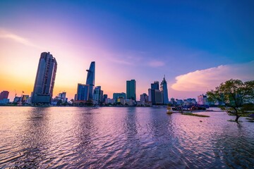 Fototapeta premium View of Bitexco Financial Tower building, buildings, roads, Thu Thiem bridge and Saigon river in Ho Chi Minh city in sunset.