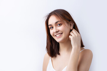 Fototapeta premium Beautiful smiling woman with clean skin, natural make-up and white teeth on a gray background