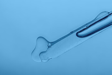Pipette with cosmetic product in water with bubbles.