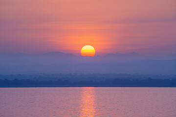 Natural landscape view of sunrise behind mountain range. Scenery of Pa Sak Chonlasit reservoir, Lopburi province, Thailand.