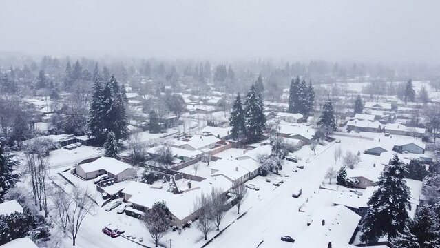 drone shot flying over neighborhood on a snowy day.