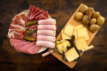 plate of charcuterie cheese for a raw and fondue raclette on a table