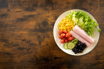 top view of a plate of fresh vegetables with ham