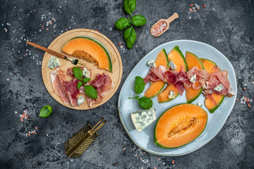 Summer appetizer with sweet melon and prosciutto and basil. Antipasti, Traditional Spanish and Italian appetizer. Top view on white stone table, Long banner format. top view