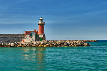 Lighthouse on the background of a beautiful sea and sky. Sea cruises and travel