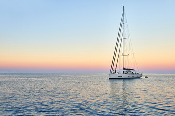Sailing yacht at sunset in the sea. Travel and yachting