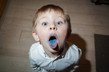 The child got his tongue dirty when he licked the blue candy.