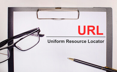 On a light wooden background glasses, a pen and a sheet of paper with the text URL Uniform Resource...