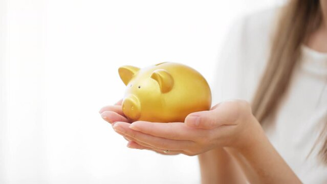 ブタの貯金箱を持つ若い女性