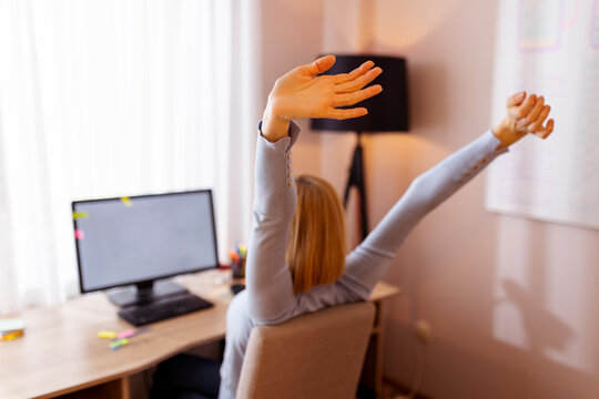 Woman stretching out while working in an office