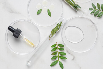 Laboratory glassware with serum and oil on white background. Natural medicine, cosmetic research,...