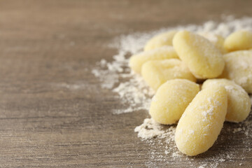 Fototapeta na wymiar Raw potato gnocchi with flour on wooden background