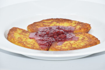 Potato pancakes with raspberry jam on the gray plate