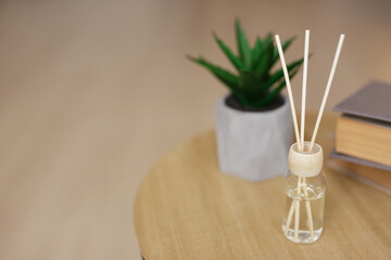close up of reed diffuser on wooden table and copy space