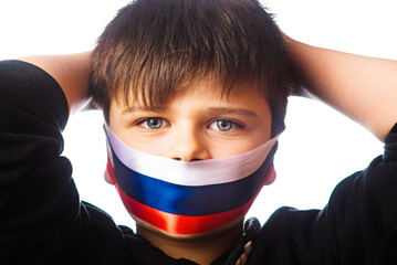 Clouse-up portrait of a boy covers his face with ribbons with flag of Russia. escalation of Ukraine