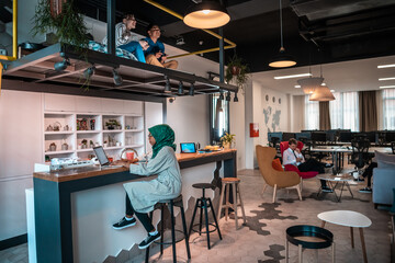 Group of casual multiethnic business people taking break from the work doing different things while enjoying free time in relaxation area at modern open plan startup office