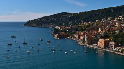 Fototapeta na wymiar Beautiful aerial view of small town Villefranche-sur-Mer at the French Riviera with the mediterranean sea on sunny day in autumn season with boats.