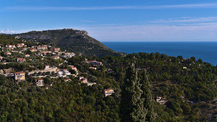 Naklejka na ściany i meble Beautiful view over the wood-covered hills of the mediterranean coast near small village Eze at the French Riviera with residential buildings.