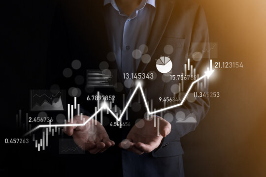 Businessman in hand hold banking business finance graph and invest in stock market investment point,economic growth and investor concept.analysis virtual stock market chart,analyze by use technology