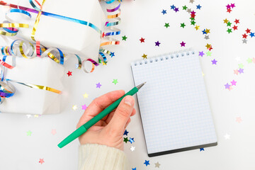 Festive decorations and notebook with wish list on white background , flat lay . Planning concept. - Image
