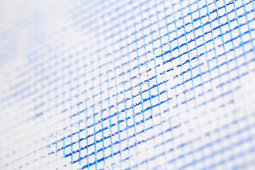 Close up of blue colored PVC reinforcing plastering mesh on the first layer of a gypsum plaster on...